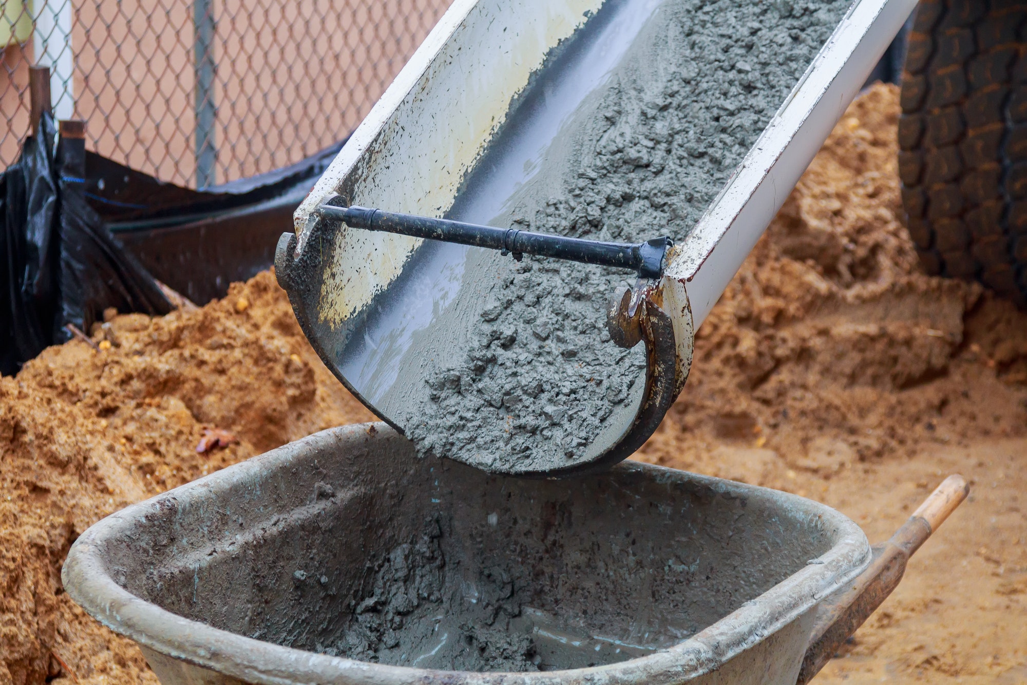 Worker pouring concrete to formwork at construction site